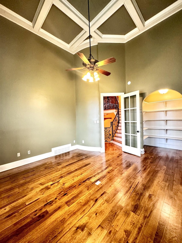 interior space with hardwood / wood-style flooring, ceiling fan, beam ceiling, coffered ceiling, and french doors