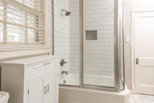 bathroom featuring bath / shower combo with glass door and toilet