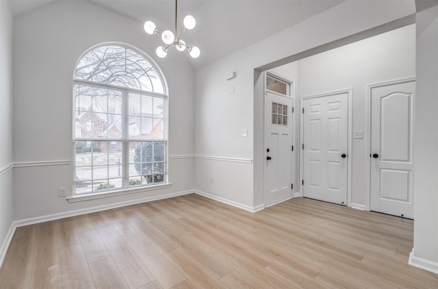 interior space featuring vaulted ceiling, an inviting chandelier, and light hardwood / wood-style flooring