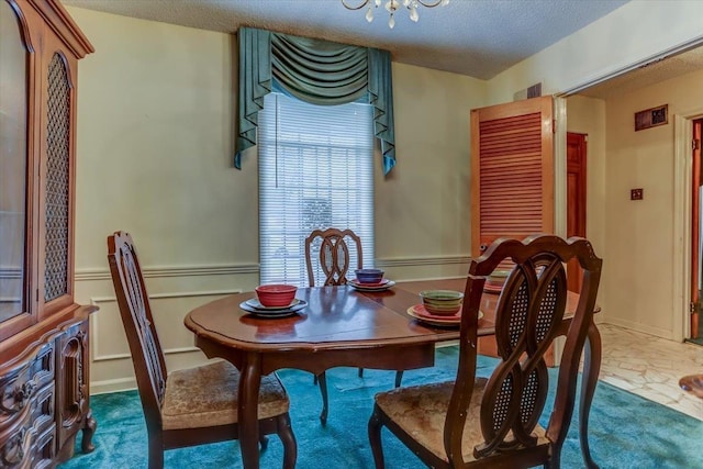 dining room featuring a chandelier and a textured ceiling