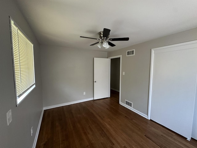 unfurnished bedroom featuring dark hardwood / wood-style flooring, a closet, and ceiling fan