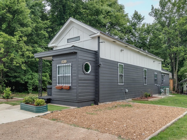 view of property exterior with central AC unit and a lawn