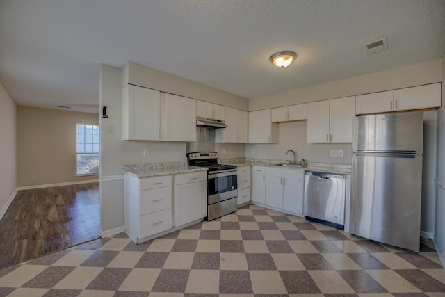 kitchen with sink, a textured ceiling, stainless steel appliances, and white cabinets