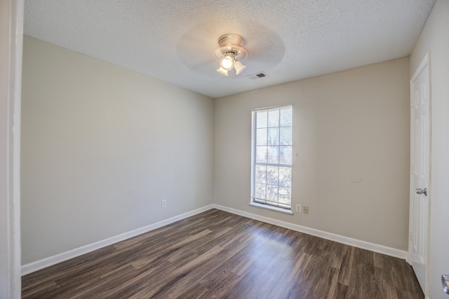 spare room with ceiling fan, a textured ceiling, and dark hardwood / wood-style flooring