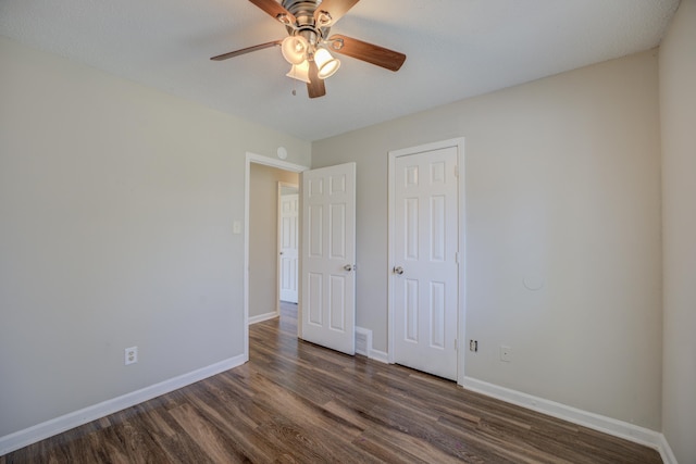 unfurnished bedroom featuring ceiling fan, dark hardwood / wood-style flooring, and a closet