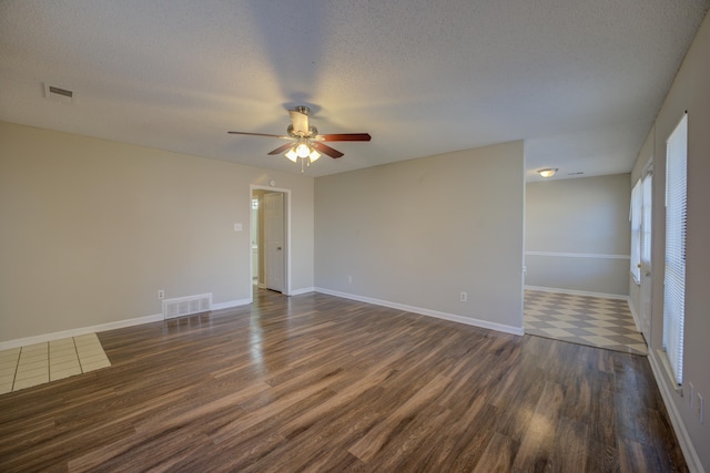 spare room with ceiling fan, dark hardwood / wood-style floors, and a textured ceiling