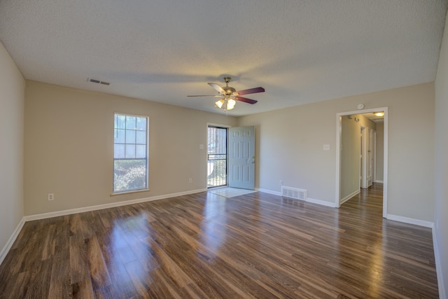 spare room with dark hardwood / wood-style floors, a textured ceiling, and ceiling fan