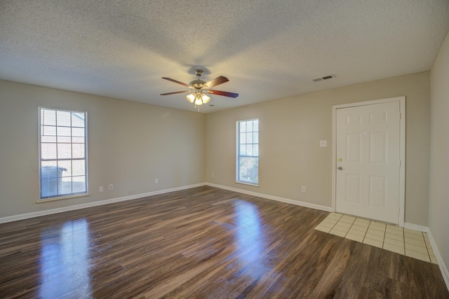 empty room featuring a textured ceiling, dark hardwood / wood-style floors, and ceiling fan