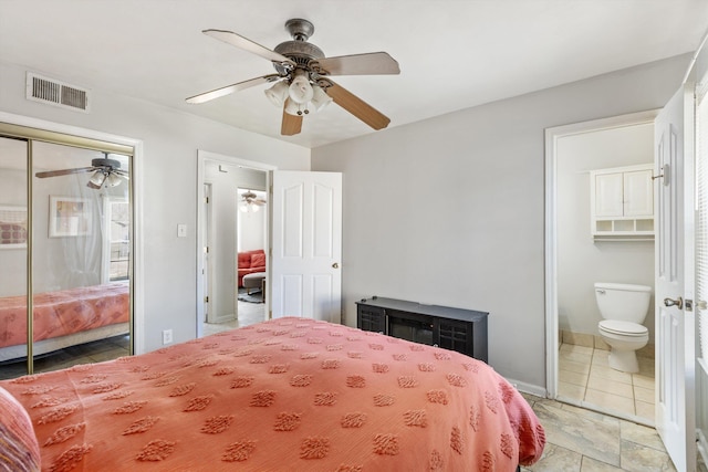 bedroom with ceiling fan, ensuite bathroom, and a closet