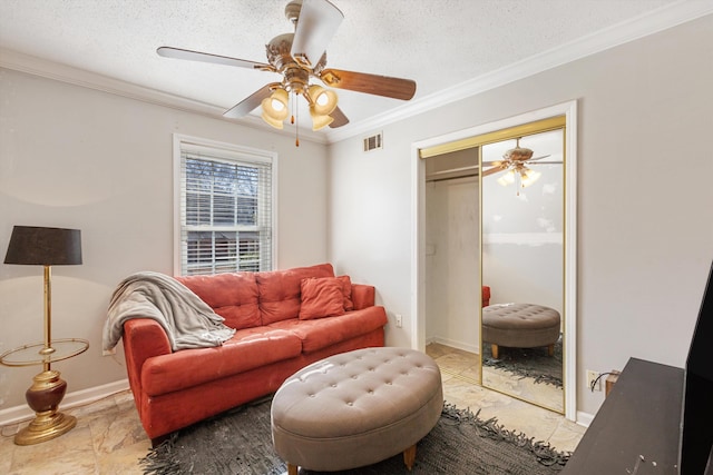 living room featuring ceiling fan, ornamental molding, and a textured ceiling