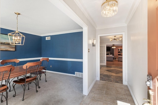 dining room with ornamental molding, carpet flooring, and a notable chandelier