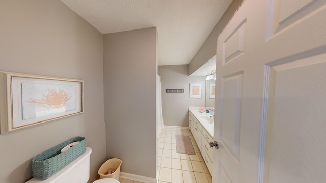 bathroom featuring vanity, a textured ceiling, tile patterned floors, and toilet