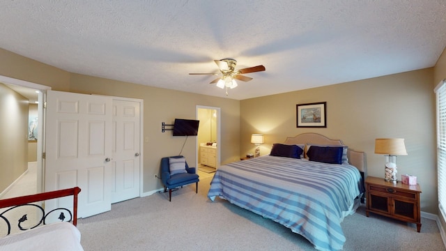 carpeted bedroom featuring ceiling fan, a textured ceiling, and ensuite bathroom