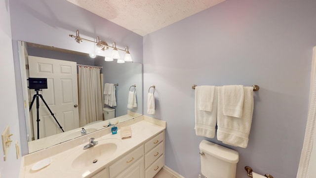 bathroom featuring vanity, toilet, and a textured ceiling