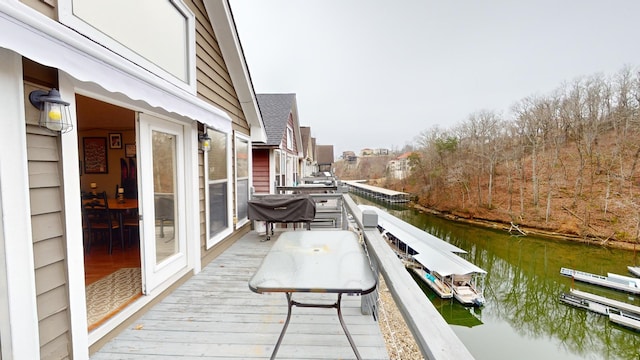 wooden terrace with a boat dock and a water view