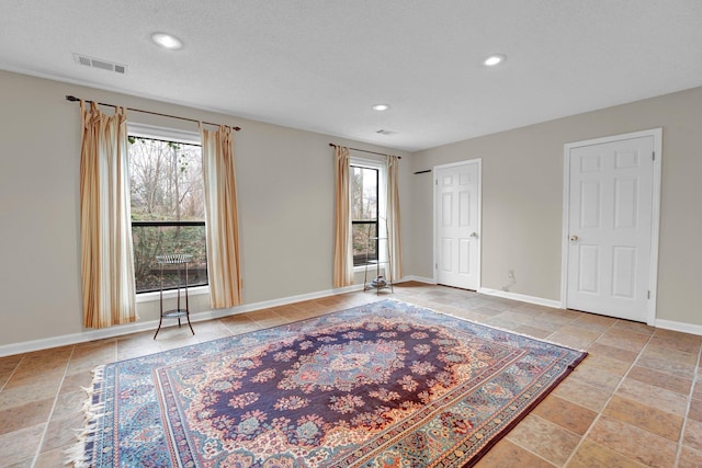 empty room with a healthy amount of sunlight and a textured ceiling