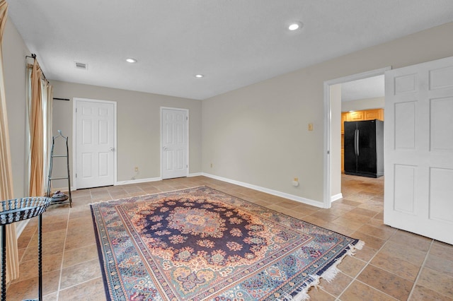 interior space featuring multiple closets and black fridge