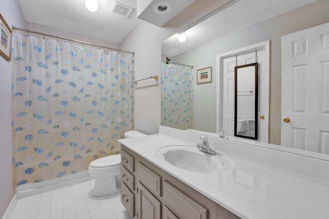 bathroom with tile patterned floors, vanity, toilet, and a textured ceiling