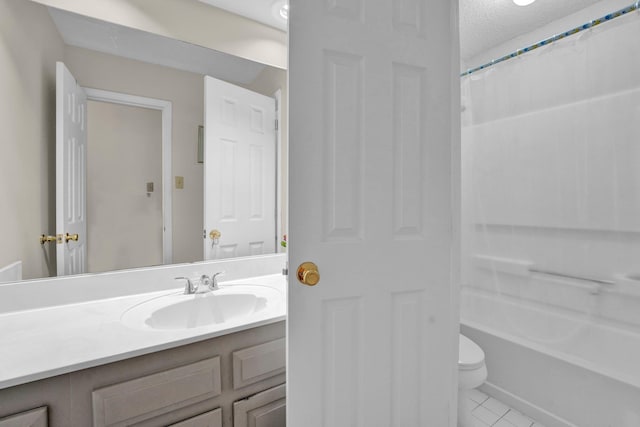 bathroom with tile patterned flooring, vanity, a textured ceiling, and toilet