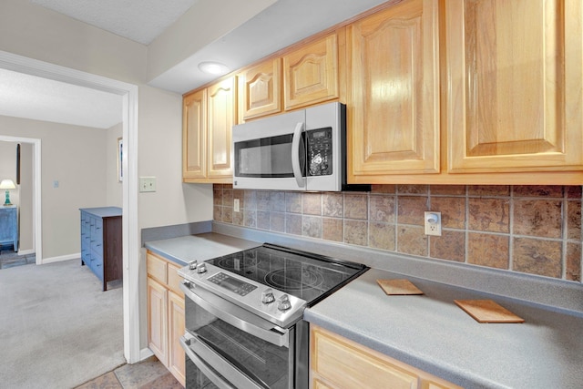 kitchen featuring backsplash, light colored carpet, light brown cabinets, and appliances with stainless steel finishes