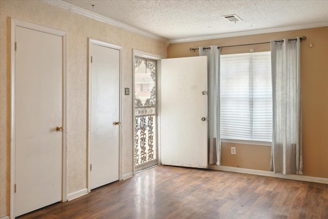 interior space featuring crown molding, dark wood-type flooring, and a textured ceiling