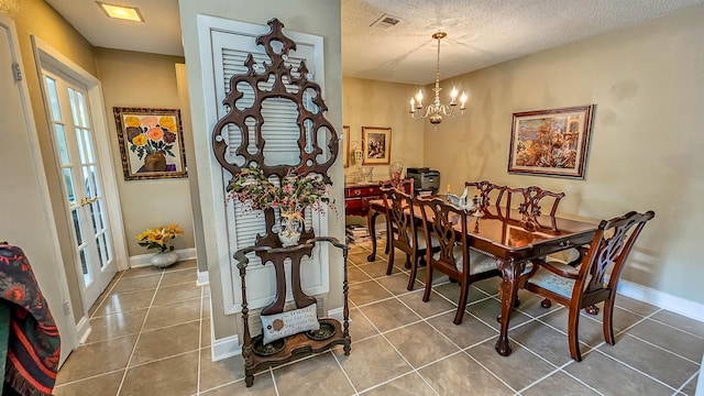 tiled dining room with a textured ceiling and a notable chandelier