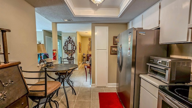 kitchen featuring white cabinetry, ornamental molding, light tile patterned floors, stainless steel fridge with ice dispenser, and a textured ceiling