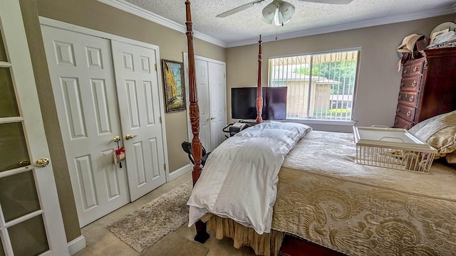 bedroom featuring two closets, ornamental molding, light colored carpet, ceiling fan, and a textured ceiling