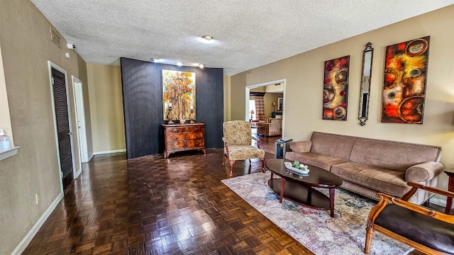 living room featuring dark parquet floors and a textured ceiling