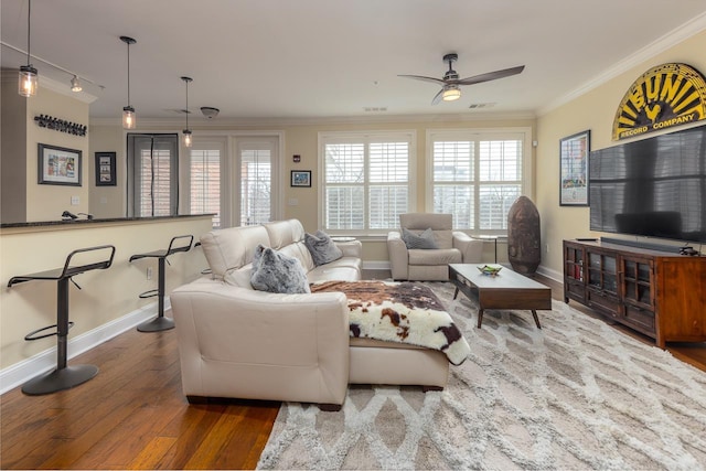 living room with hardwood / wood-style floors, crown molding, plenty of natural light, and ceiling fan