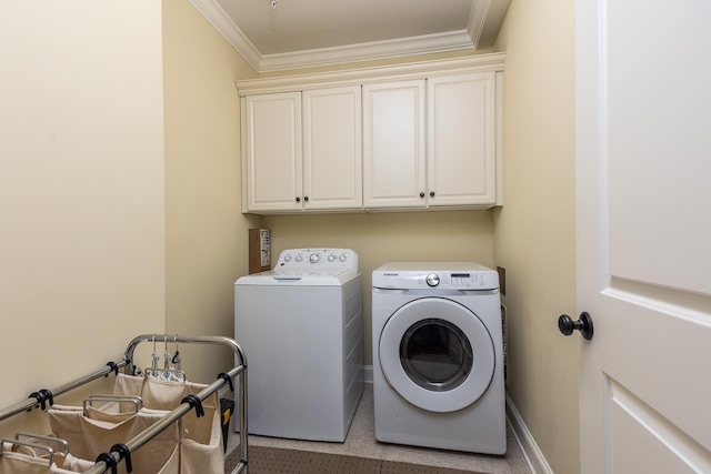 washroom featuring cabinets, ornamental molding, and washing machine and clothes dryer