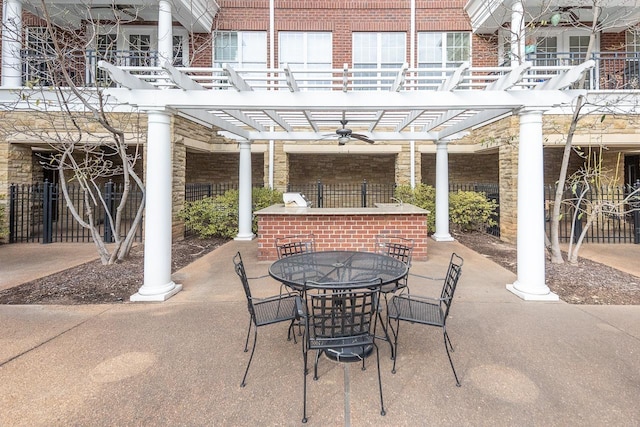 view of patio / terrace with exterior bar, ceiling fan, and a pergola