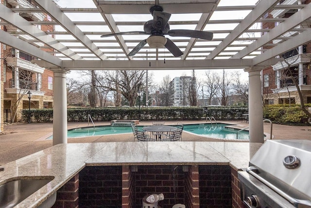 view of swimming pool featuring a bar, grilling area, and area for grilling