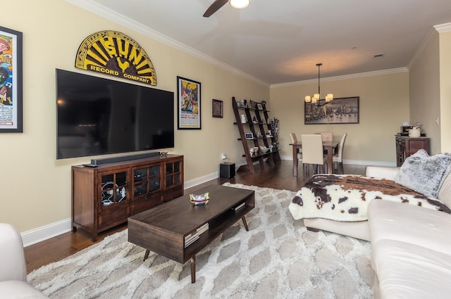 living room featuring hardwood / wood-style flooring, ornamental molding, and ceiling fan with notable chandelier