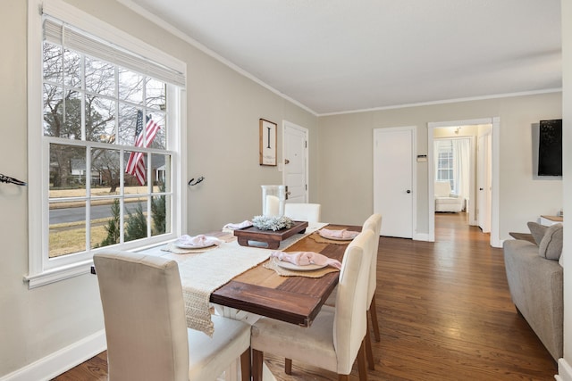 dining room with crown molding, a healthy amount of sunlight, and dark hardwood / wood-style flooring