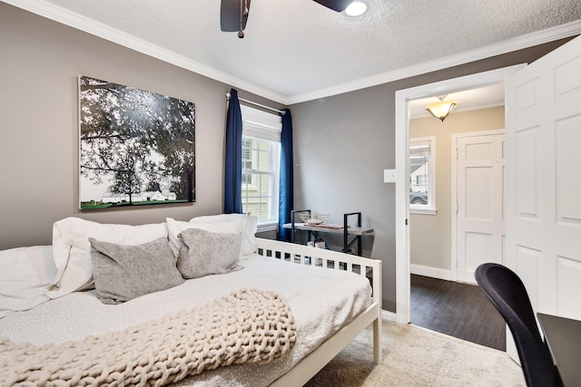 bedroom featuring ceiling fan, wood-type flooring, ornamental molding, and a textured ceiling