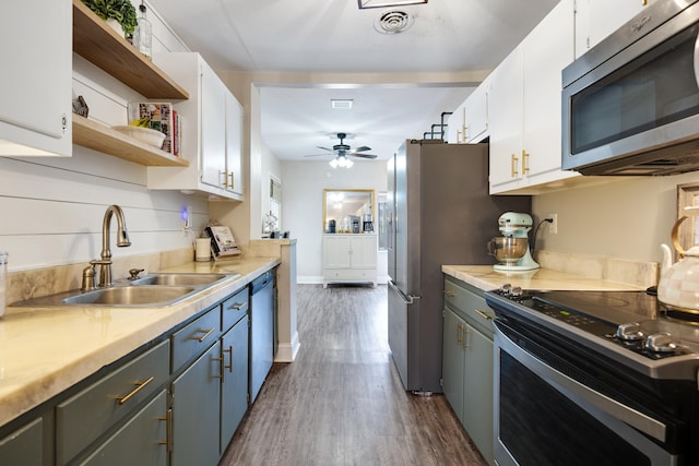 kitchen with sink, white cabinetry, appliances with stainless steel finishes, dark hardwood / wood-style flooring, and ceiling fan