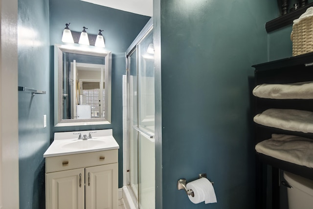 bathroom featuring an enclosed shower, vanity, and toilet