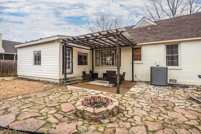 rear view of property featuring a patio, an outdoor living space with a fire pit, central AC unit, and a pergola