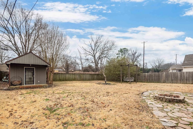 view of yard featuring an outbuilding and a fire pit