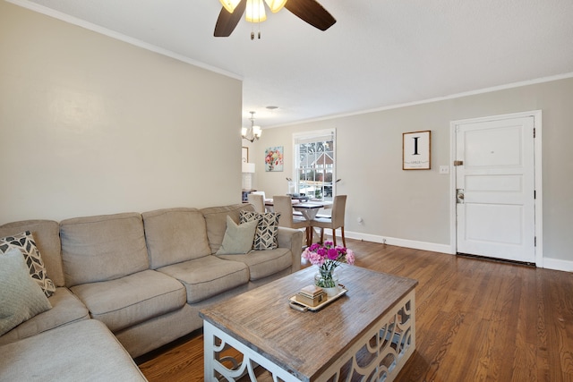 living room featuring crown molding, dark wood-type flooring, and ceiling fan with notable chandelier