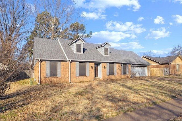 cape cod house featuring a garage and a front yard