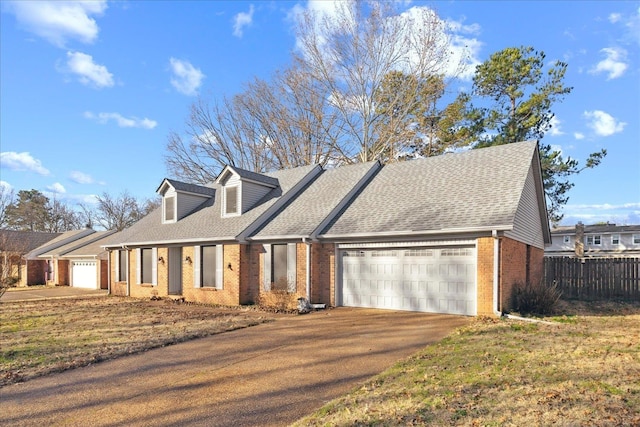 cape cod house featuring a garage and a front yard