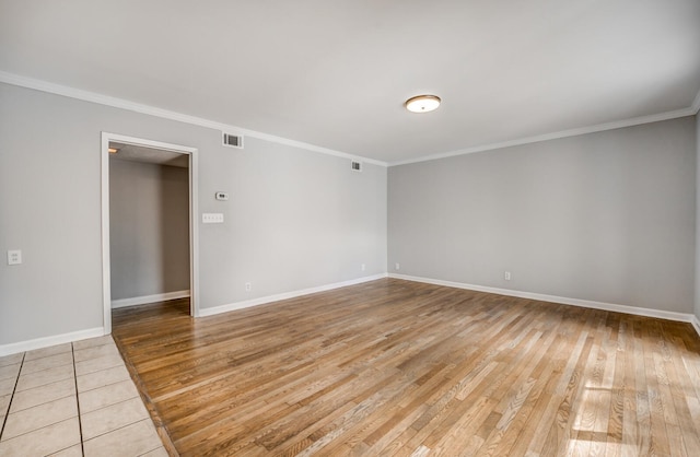 empty room with ornamental molding and light hardwood / wood-style flooring