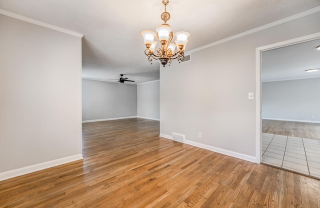 spare room with hardwood / wood-style floors, crown molding, and ceiling fan with notable chandelier