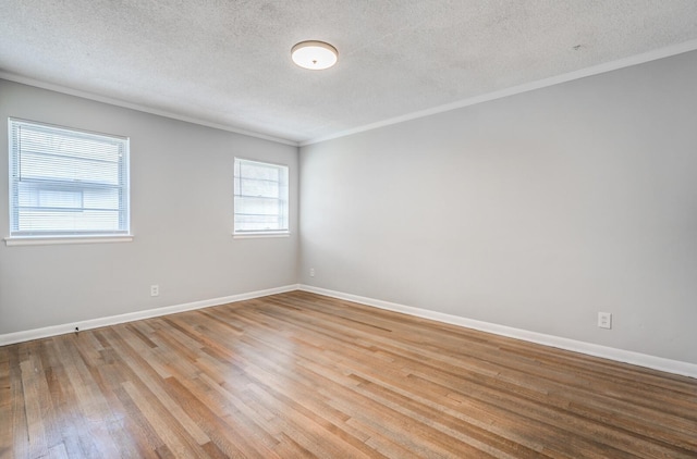 spare room with crown molding, light hardwood / wood-style floors, and a textured ceiling