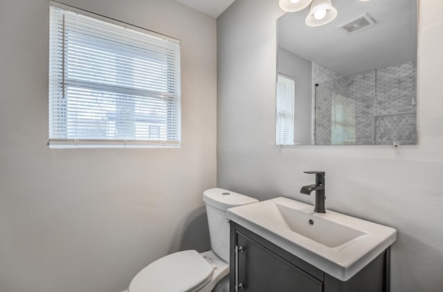 bathroom with vanity, walk in shower, and toilet