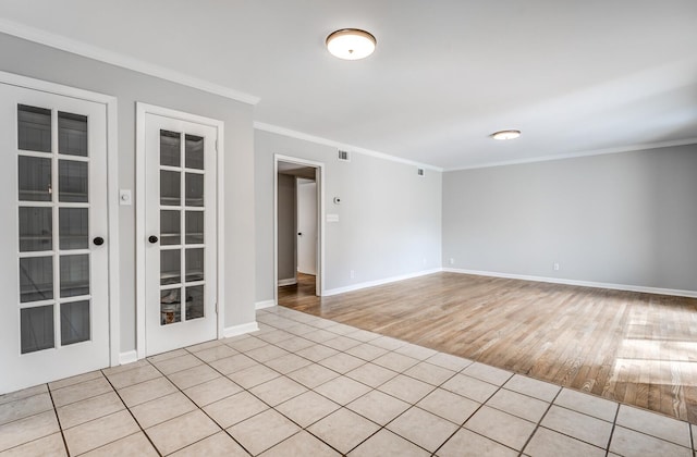 spare room featuring ornamental molding and light wood-type flooring