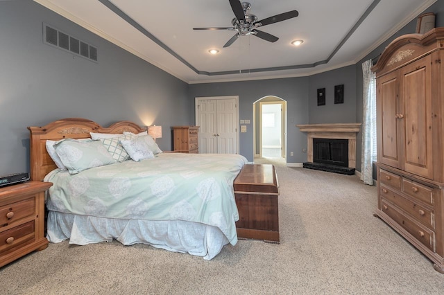 carpeted bedroom featuring crown molding, ceiling fan, and a closet