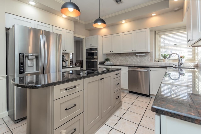 kitchen with white cabinetry, appliances with stainless steel finishes, sink, and a center island